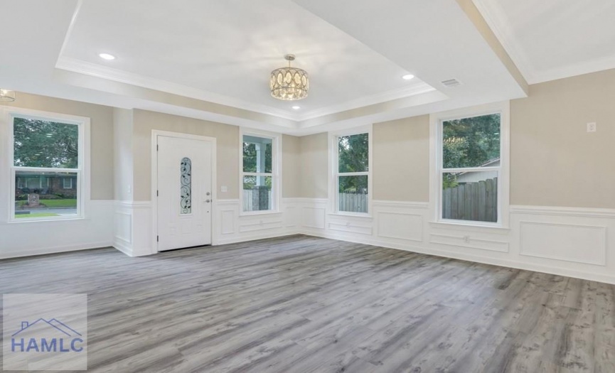 Open concept living/dining room area with crown mo