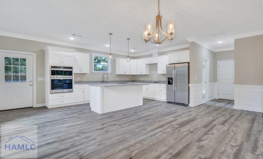 Open concept living/dining room area with crown mo